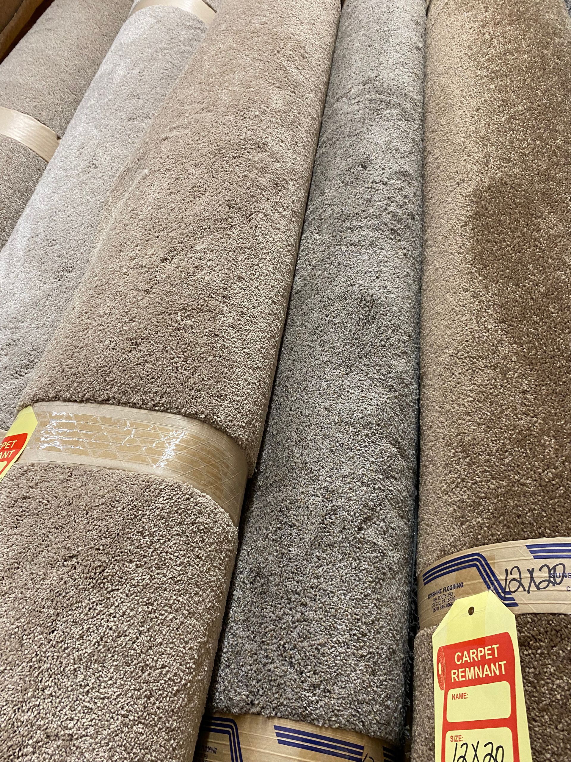 A bunch of carpets are stacked on top of each other in a store.
