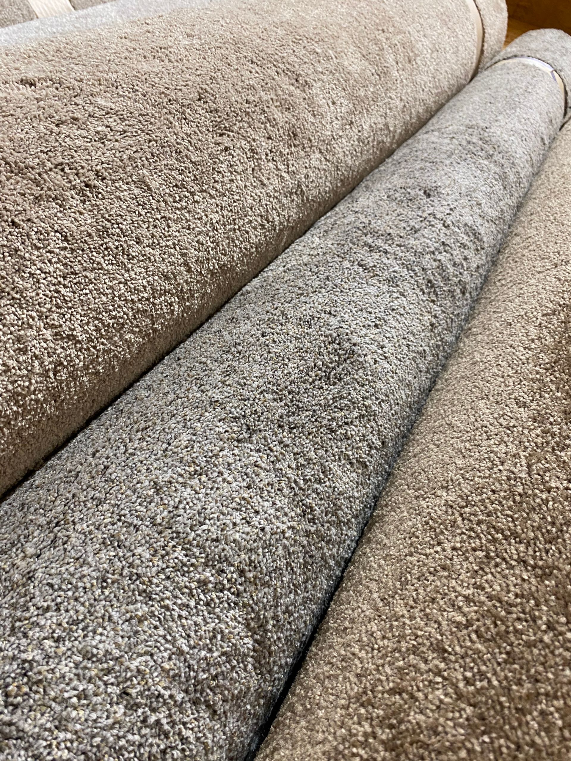 Three rolls of carpet are stacked on top of each other on a table.