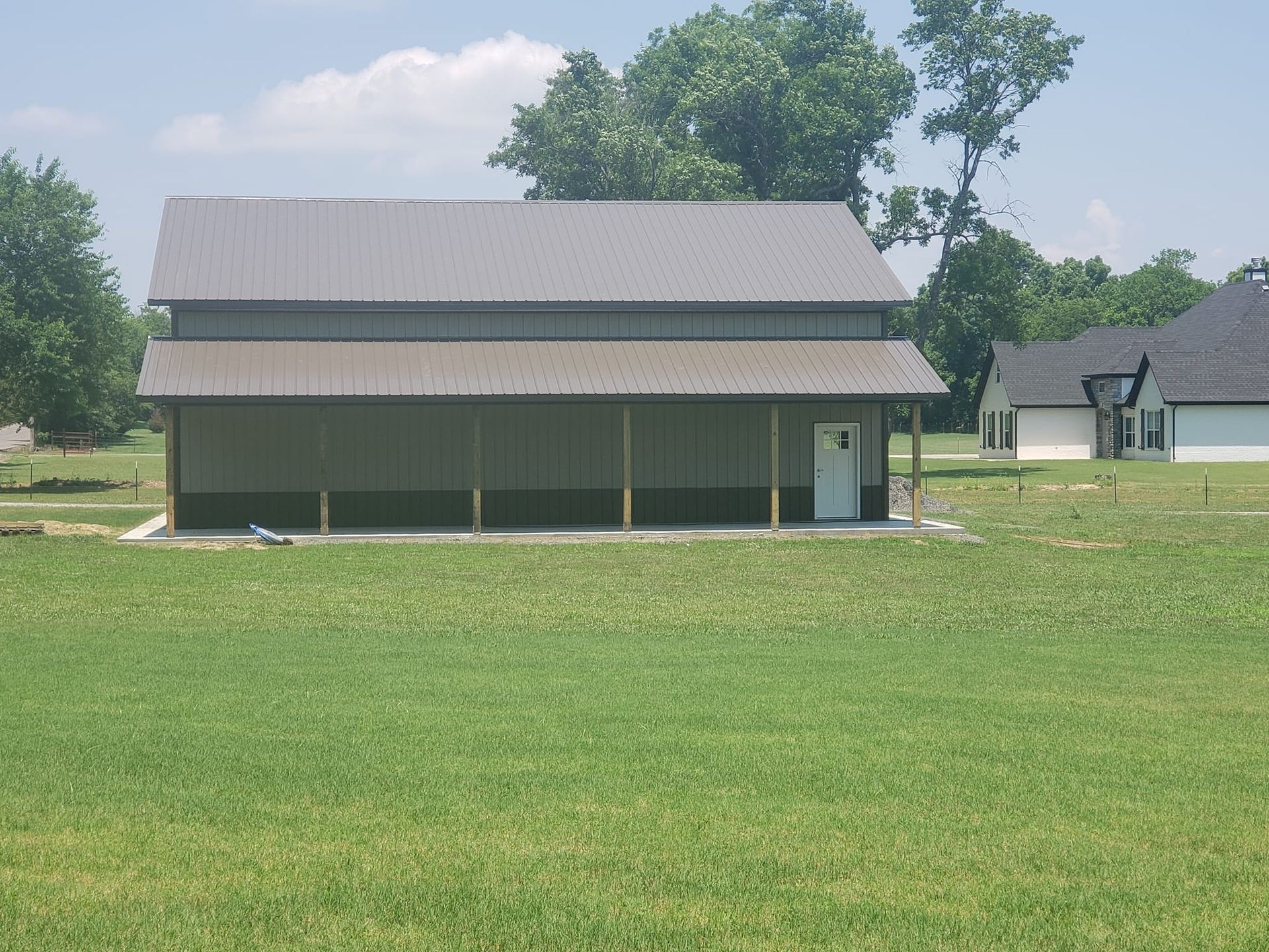 A large barn in the middle of a grassy field