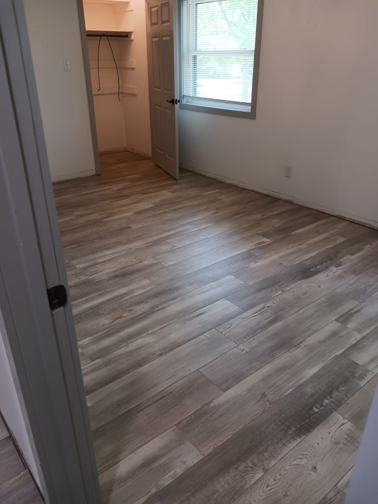 A bedroom with hardwood floors and a walk in closet.