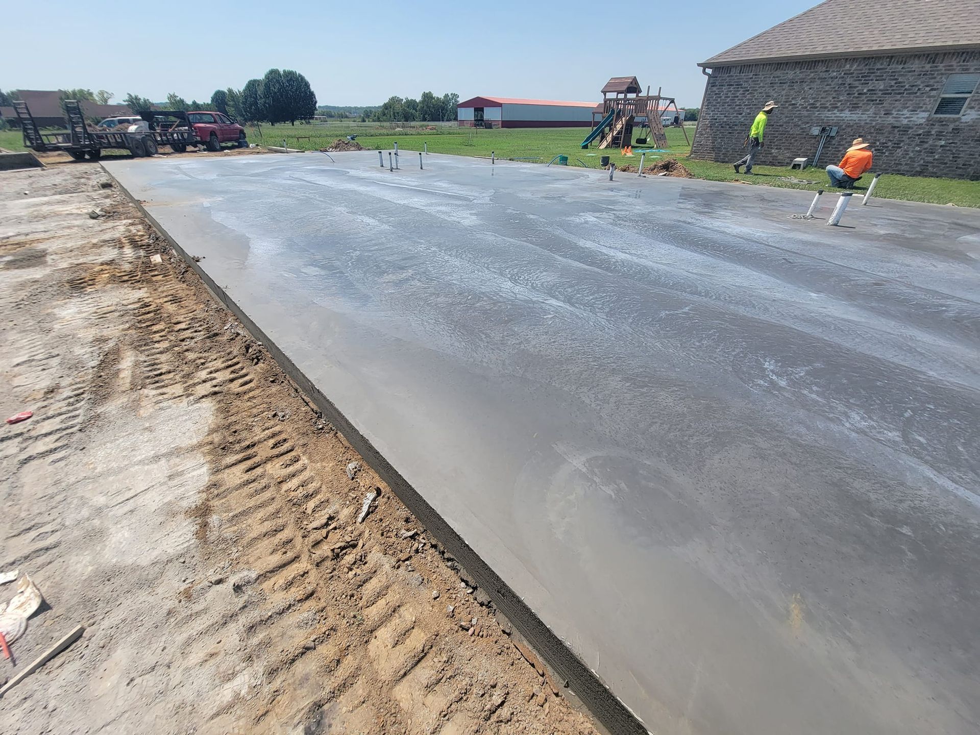 A concrete driveway is being built in front of a house.