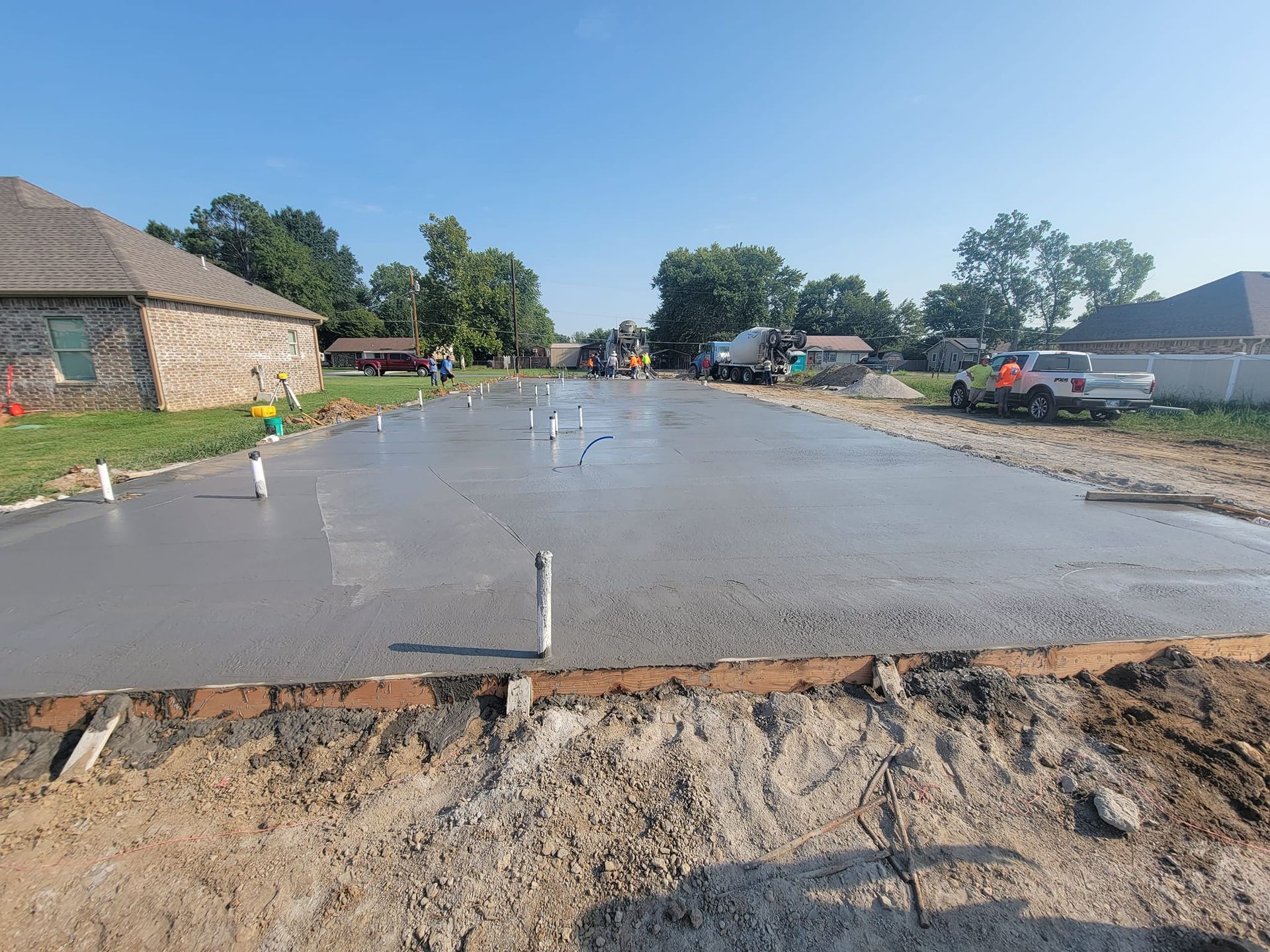 A concrete driveway is being built in a residential area.