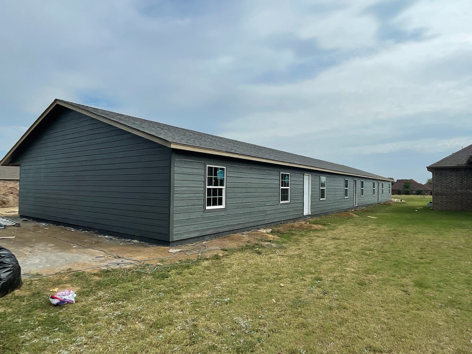 A row of houses are being built in a grassy field.