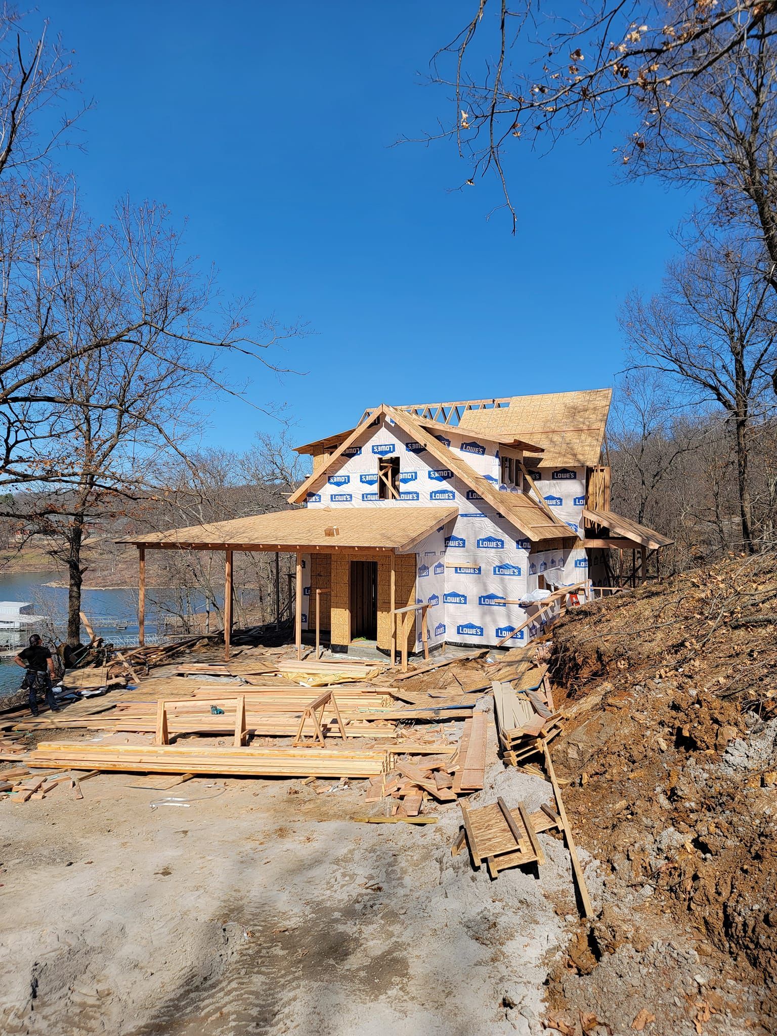 A house is being built on a hill next to a body of water.
