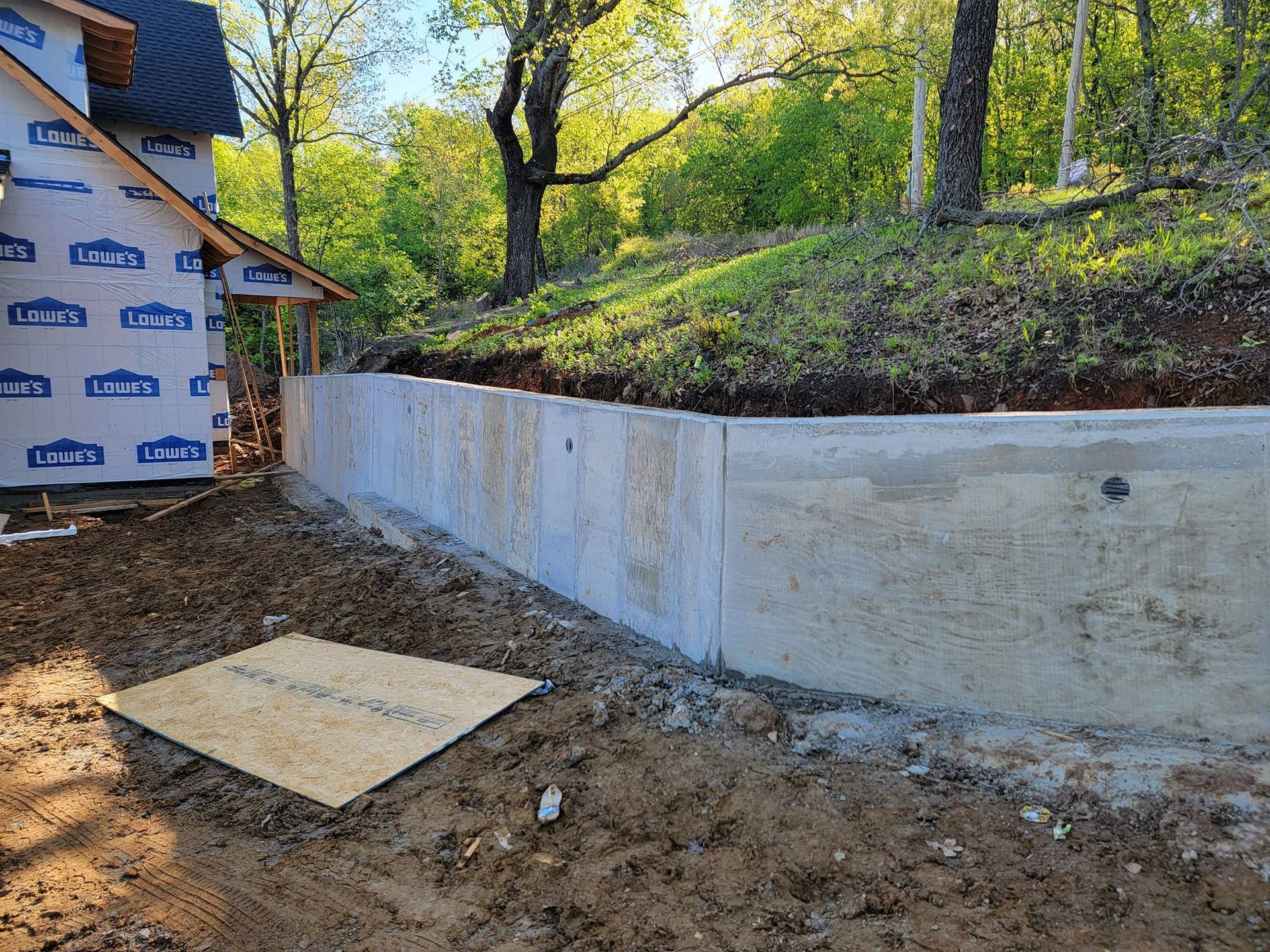 A concrete wall is being built in the backyard of a house.