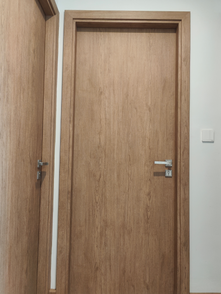 Wooden interior door with silver handle in a plain hallway