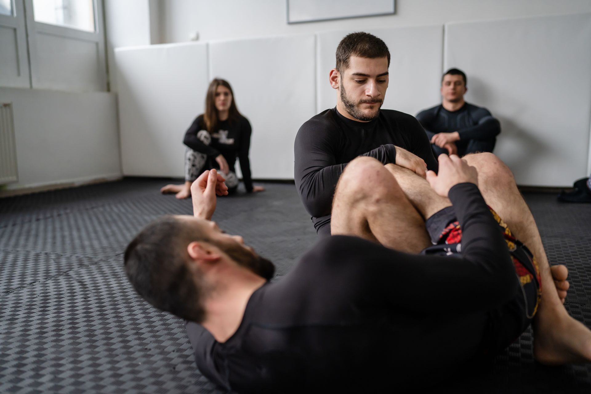 A group of people are practicing martial arts in a gym.