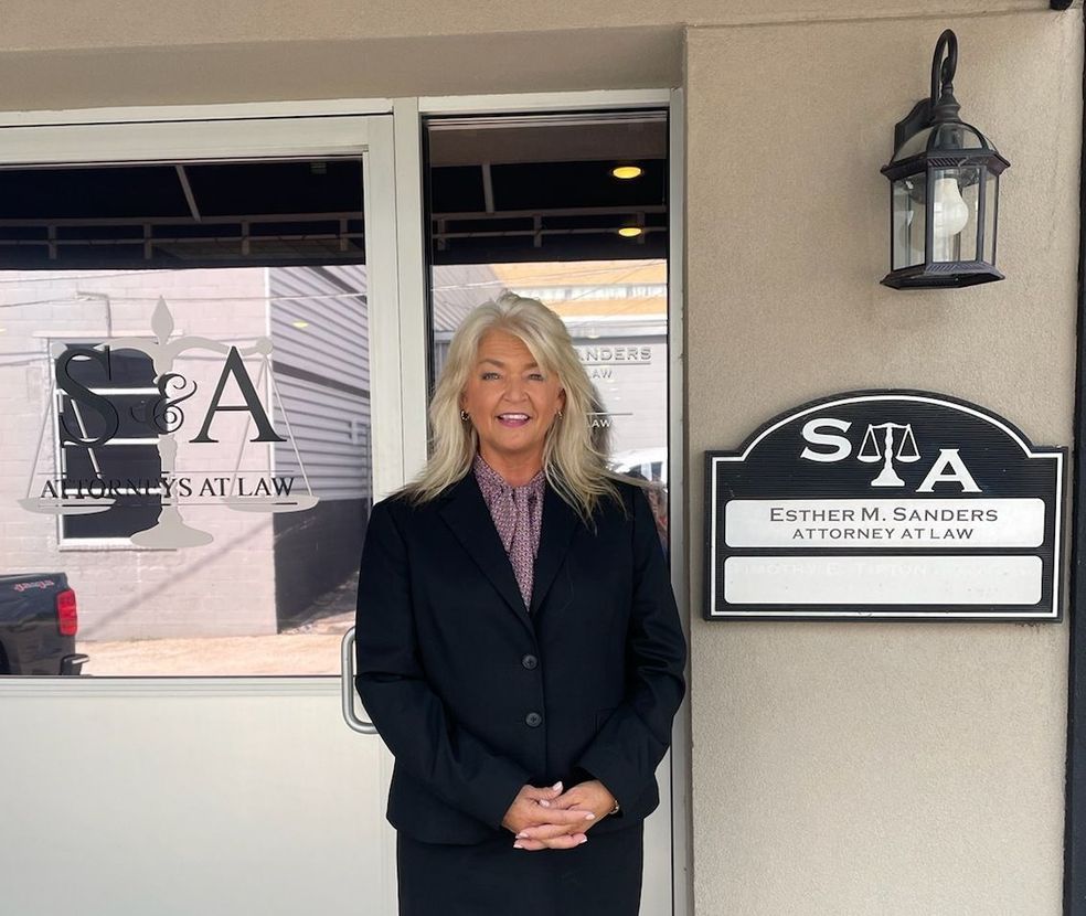 A woman in a suit is standing in front of a building with a sign that says sta