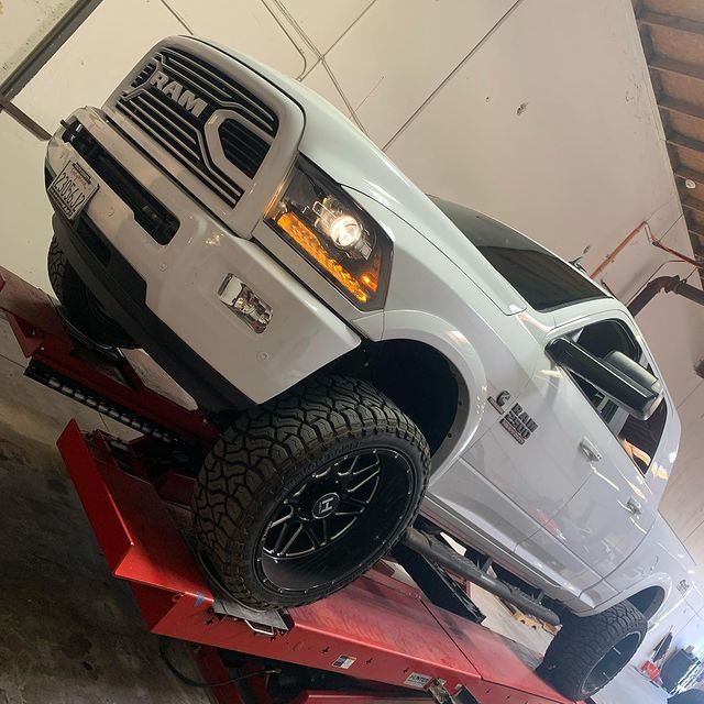 A white ram truck on a red lift | Choose JCR Performance for Auto Repairs in Sacramento, CA