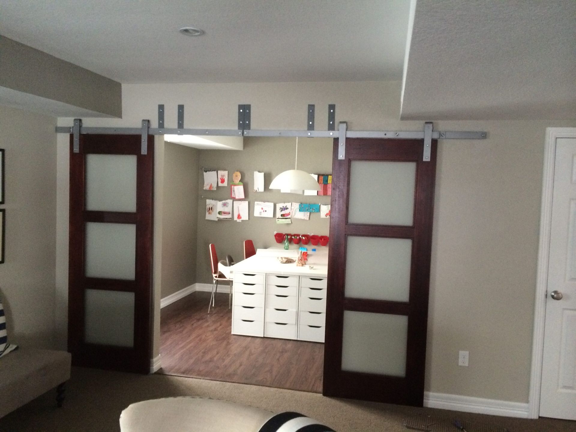 A living room with sliding barn doors leading to a dining room