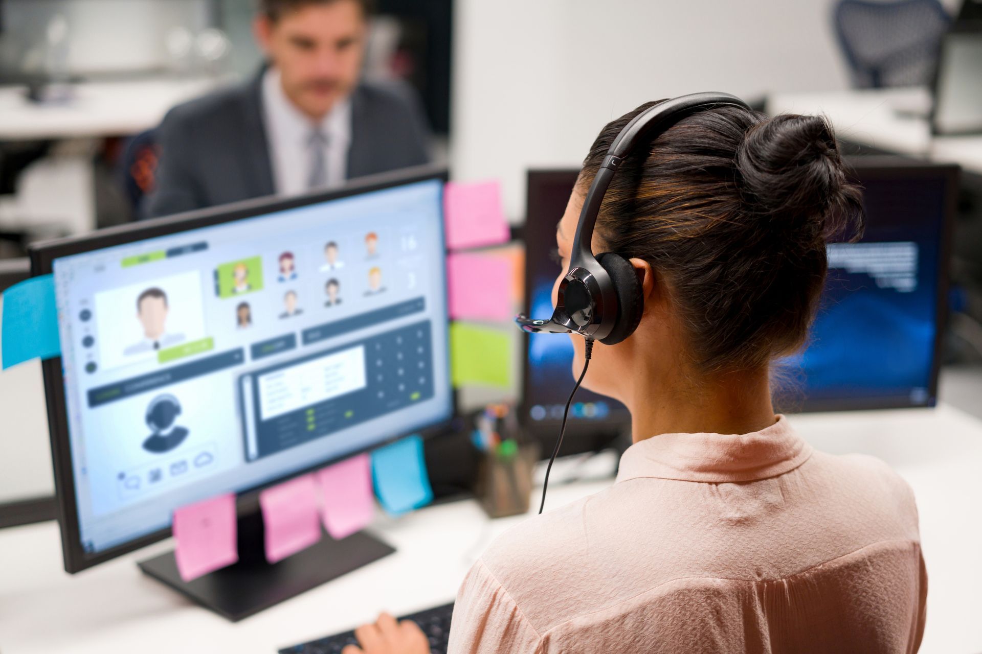 A woman with headphones at a computer, representing TELWORX in Whittier, CA, specializing in VoIP Co