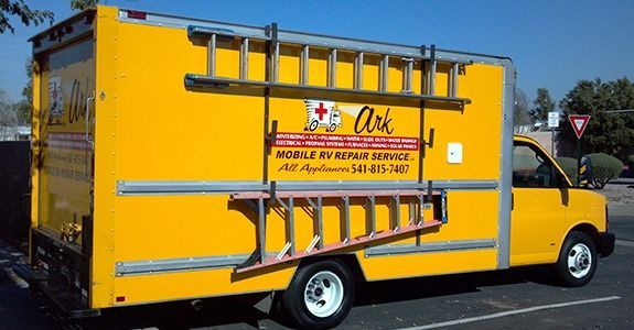 Yellow service truck with ladders, logo for appliance repair.