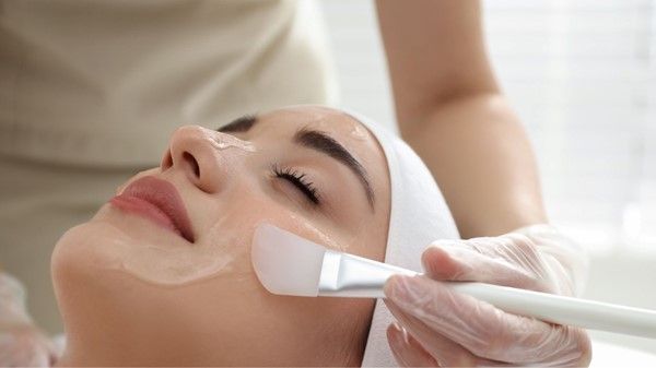 A fresh, glowing woman enjoying a professional facial treatment.