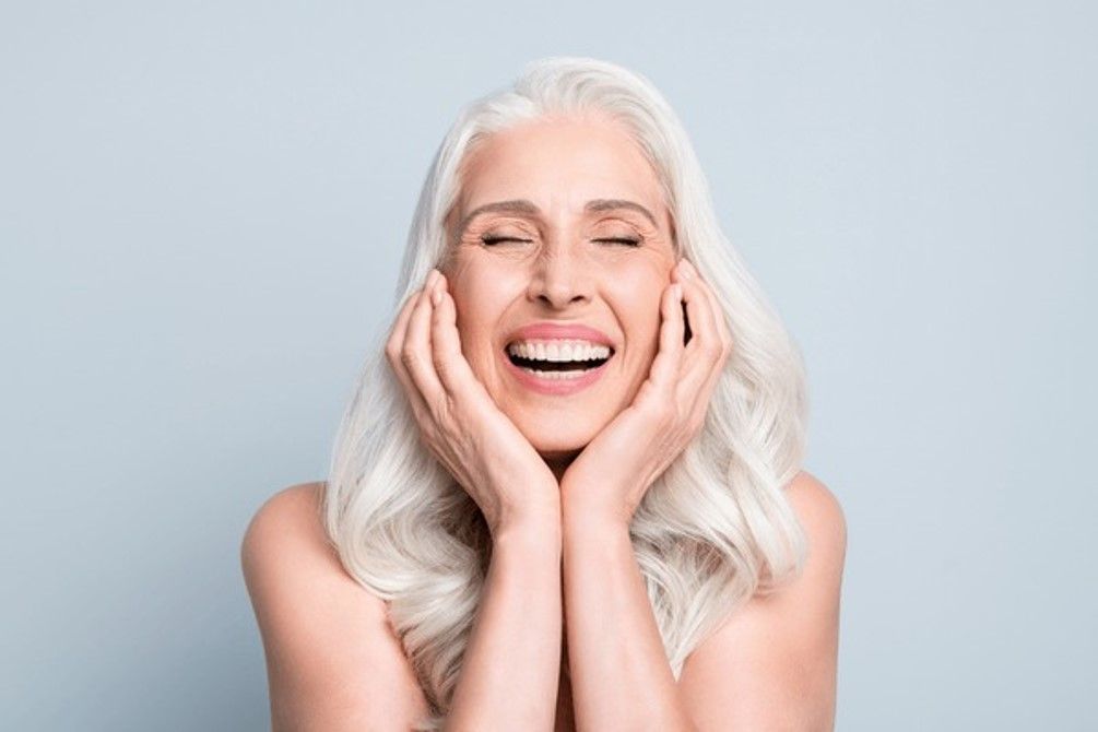 Woman in her 30s applying pea-sized amount of retinol cream