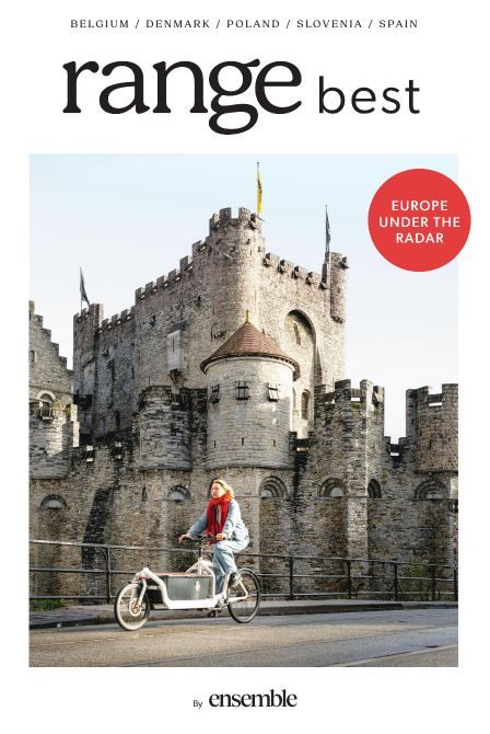Woman on bicycle in front of stone castle, with “range best” magazine cover text and red “Europe under the radar” badge