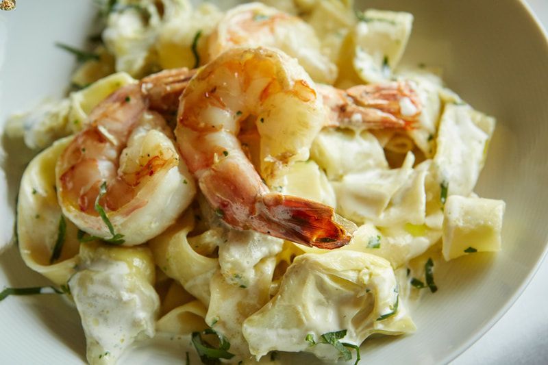 shrimp pasta A close up of a plate of pasta with shrimp and artichokes.