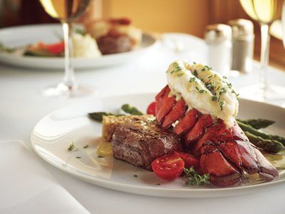 surf and turf meal A white plate topped with a steak and lobster tail