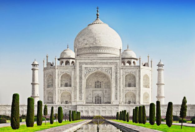 picture of the taj mahal The taj mahal is a very large white building with a blue sky in the background.