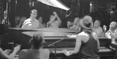 piano man singing A woman is playing a piano in front of a crowd of people.