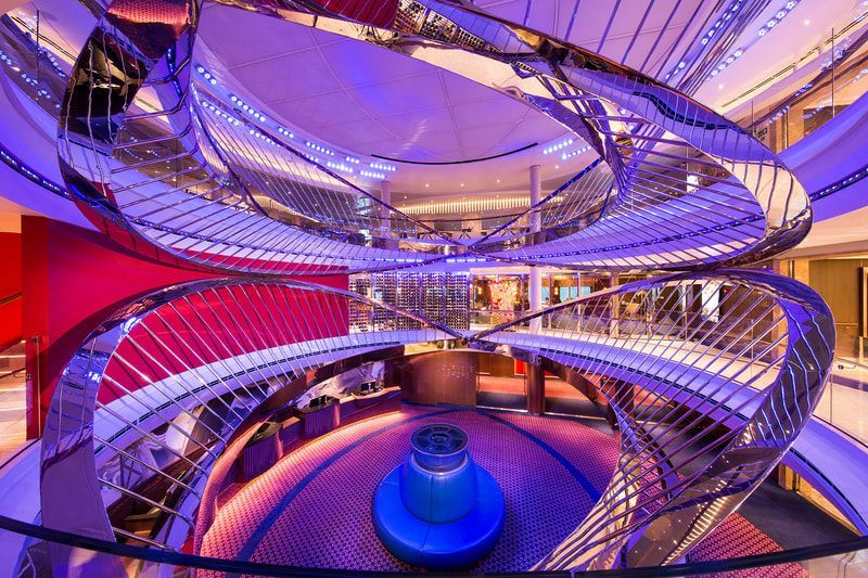 staircase in cruise ship A spiral staircase in a building with purple lights.