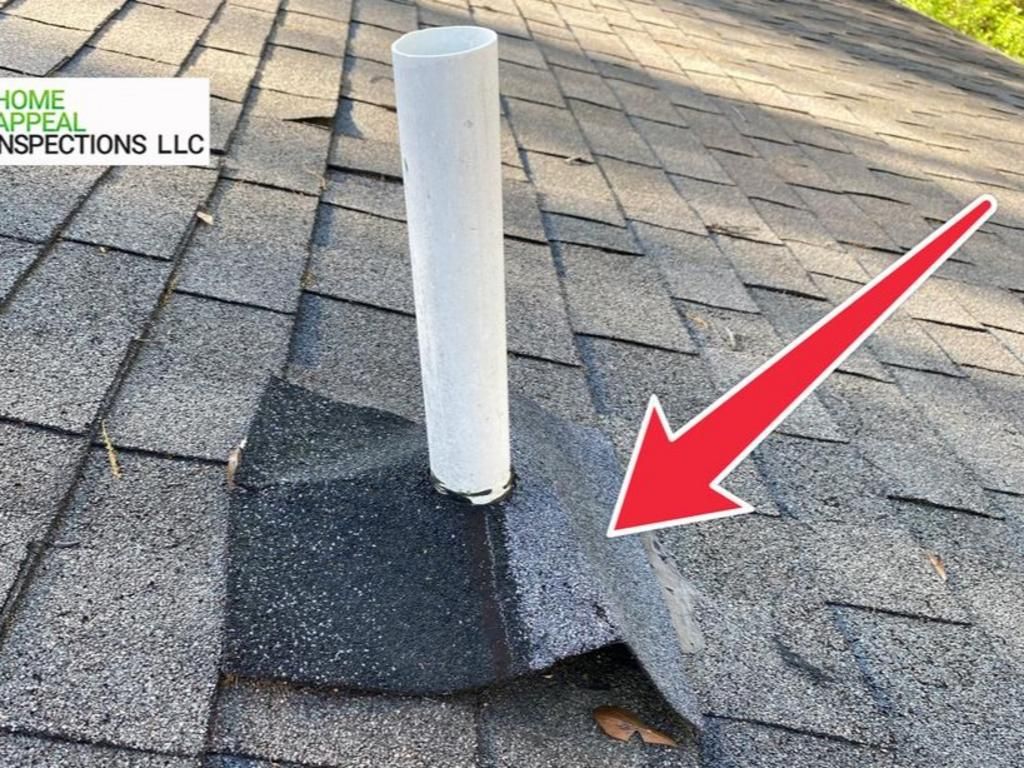 A red arrow points to a damaged, lifted roof shingle around a white plumbing vent pipe on an asphalt shingled roof.