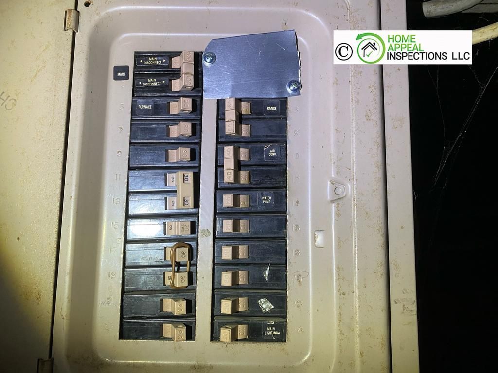 An electrical panel with a metal cover plate installed over an open slot, featuring a Home Appeal Inspections LLC logo.