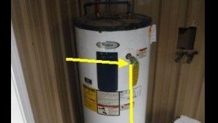 A water heater with a yellow arrow pointing to the Temperature and Pressure relief valve and its discharge pipe.