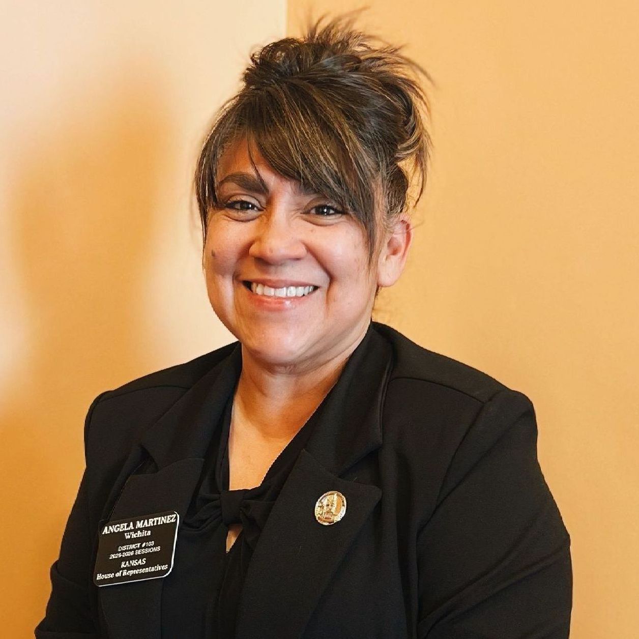 A woman wearing a black jacket and a name tag that says miss