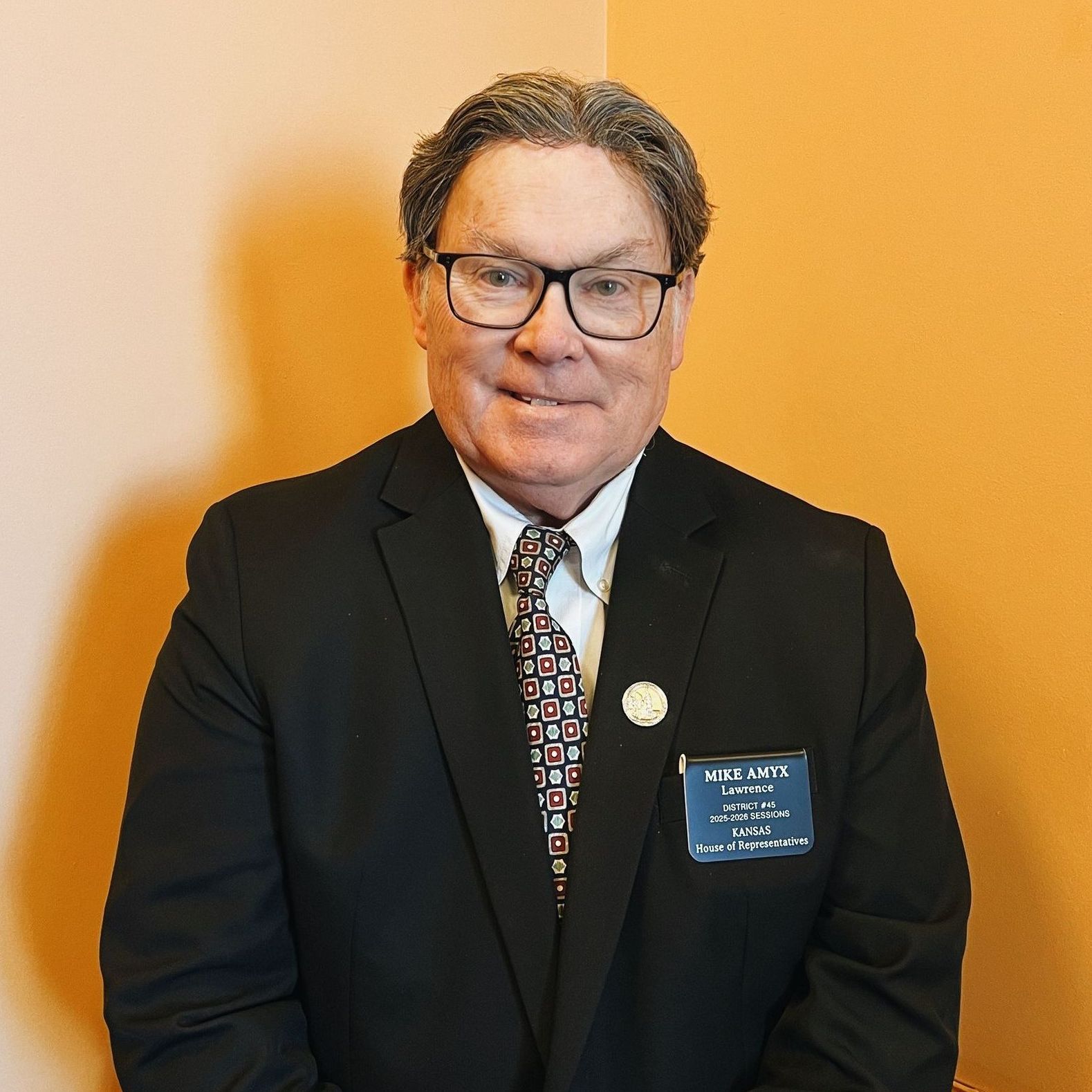 A man in a suit and tie is smiling for the camera.