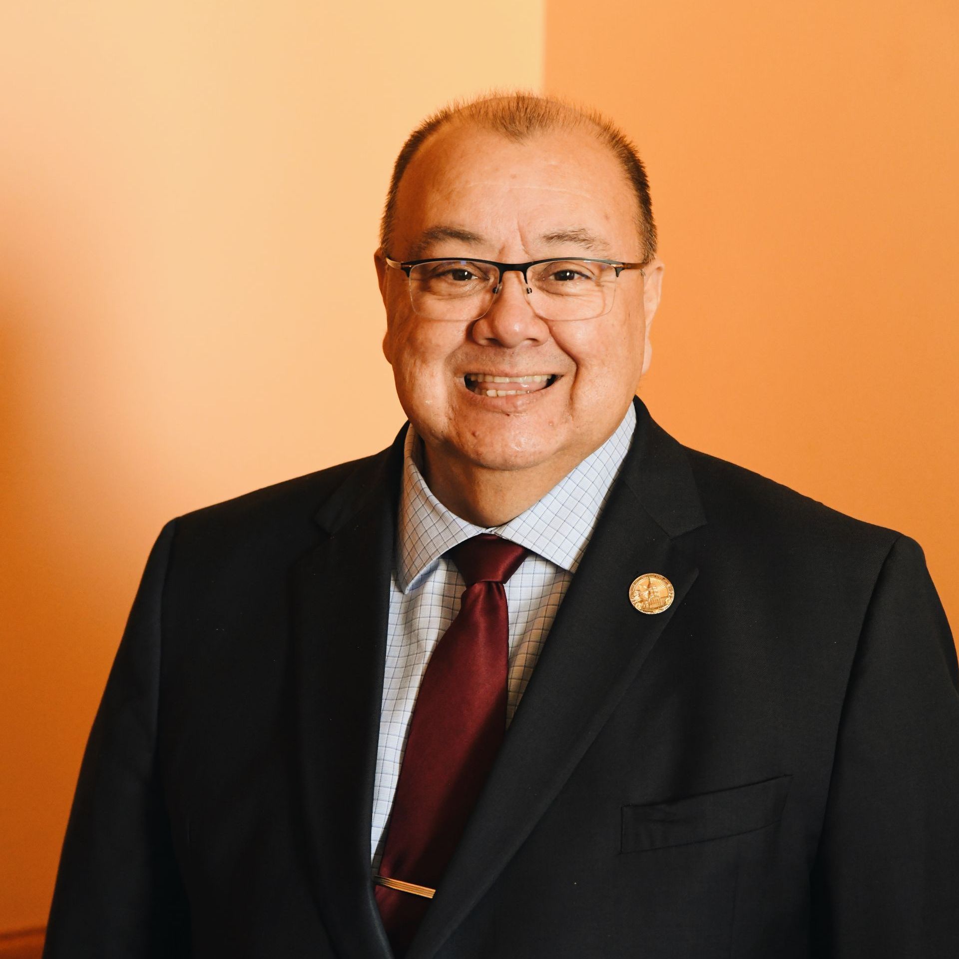 A man in a suit and tie is smiling for the camera.