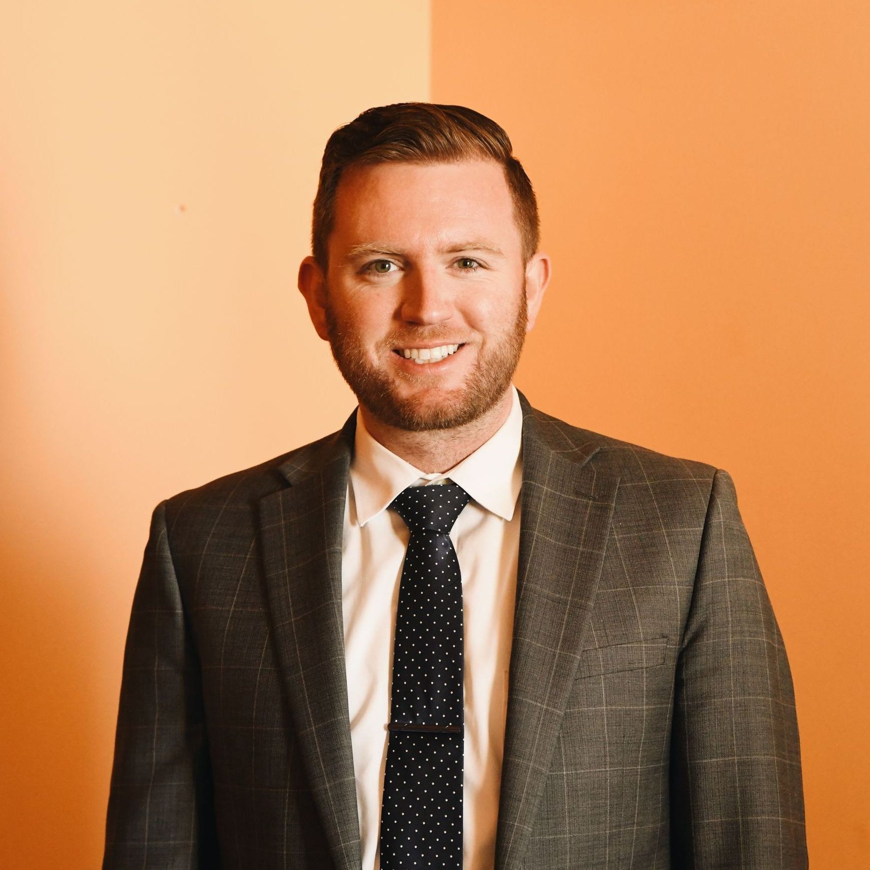 A man in a suit and tie is smiling for the camera