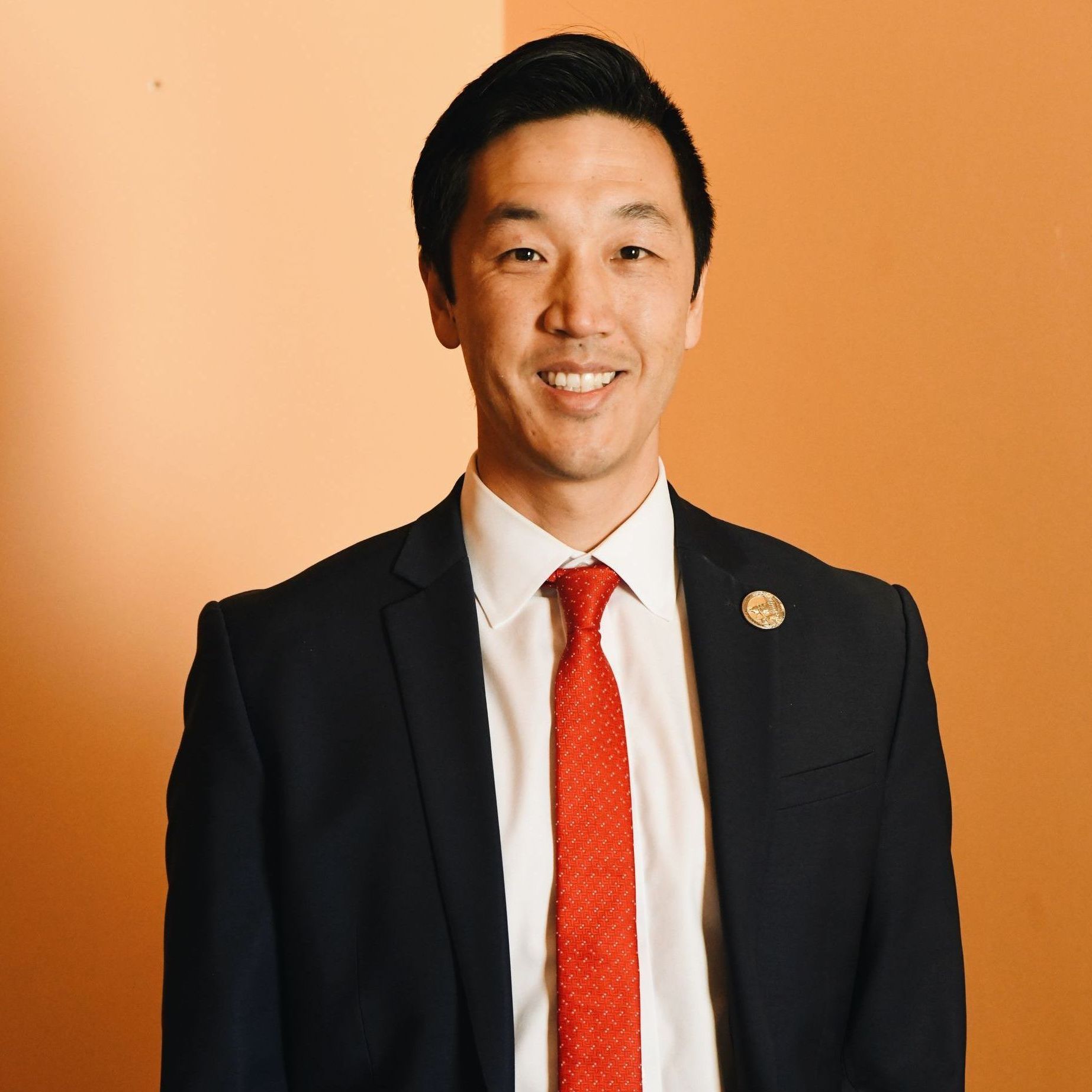 A man in a suit and tie is smiling for the camera.