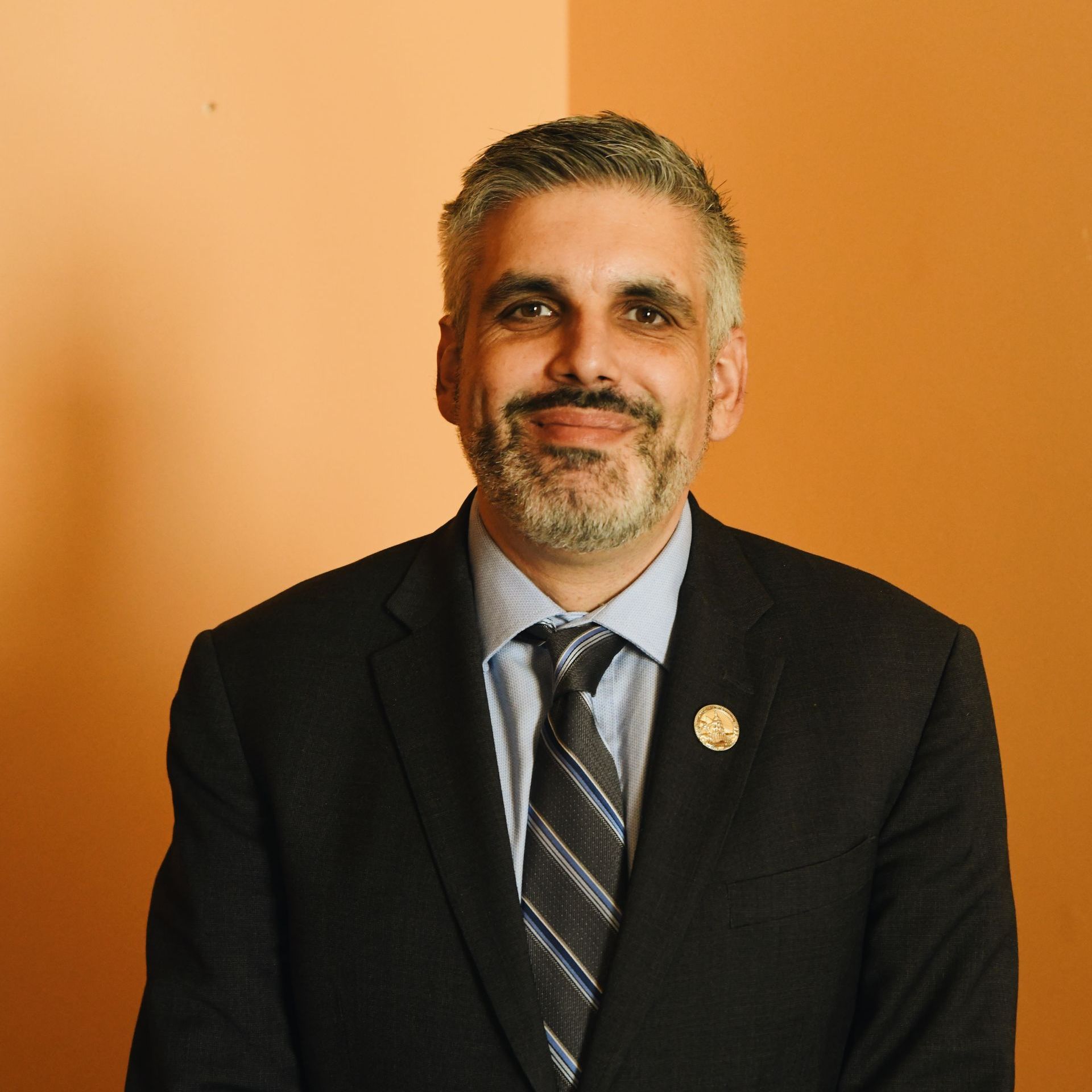 A man with a beard is wearing a suit and tie