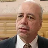 A bald man with a beard is wearing a suit and tie.
