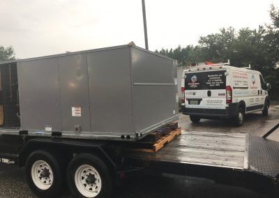 Two vans are parked next to each other on a trailer.
