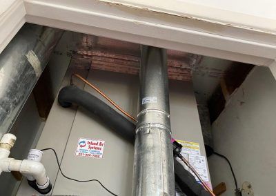 A room with a furnace and pipes coming out of it.