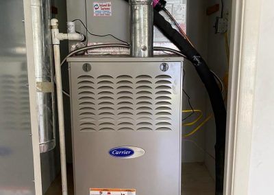 A carrier air conditioner is sitting inside of a cabinet.