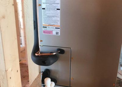 A heater is being installed in a room in a house under construction.