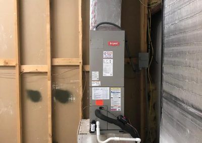 An air conditioner is sitting in a room next to a wall.