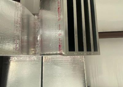 A close up of a metal duct in a room.