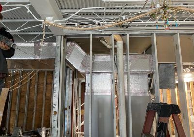 A man is working on the ceiling of a building.