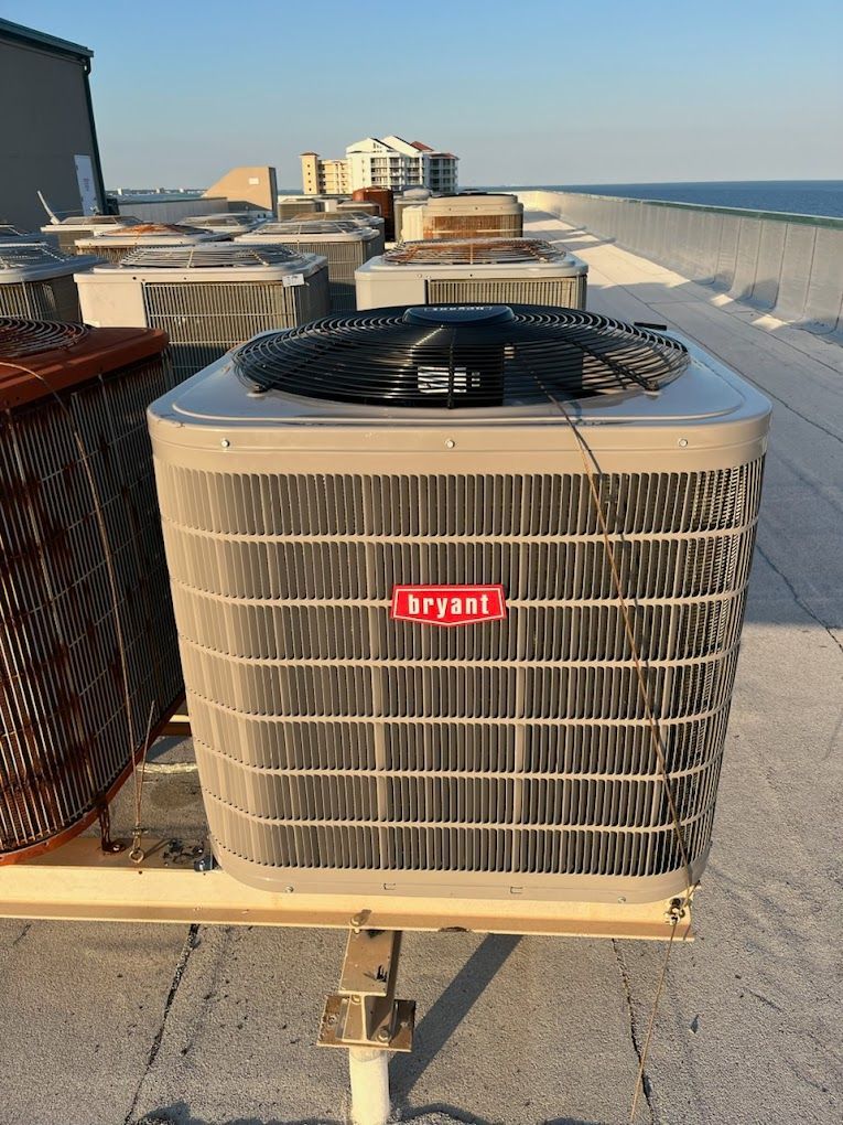 A large bryant air conditioner is sitting on top of a roof.