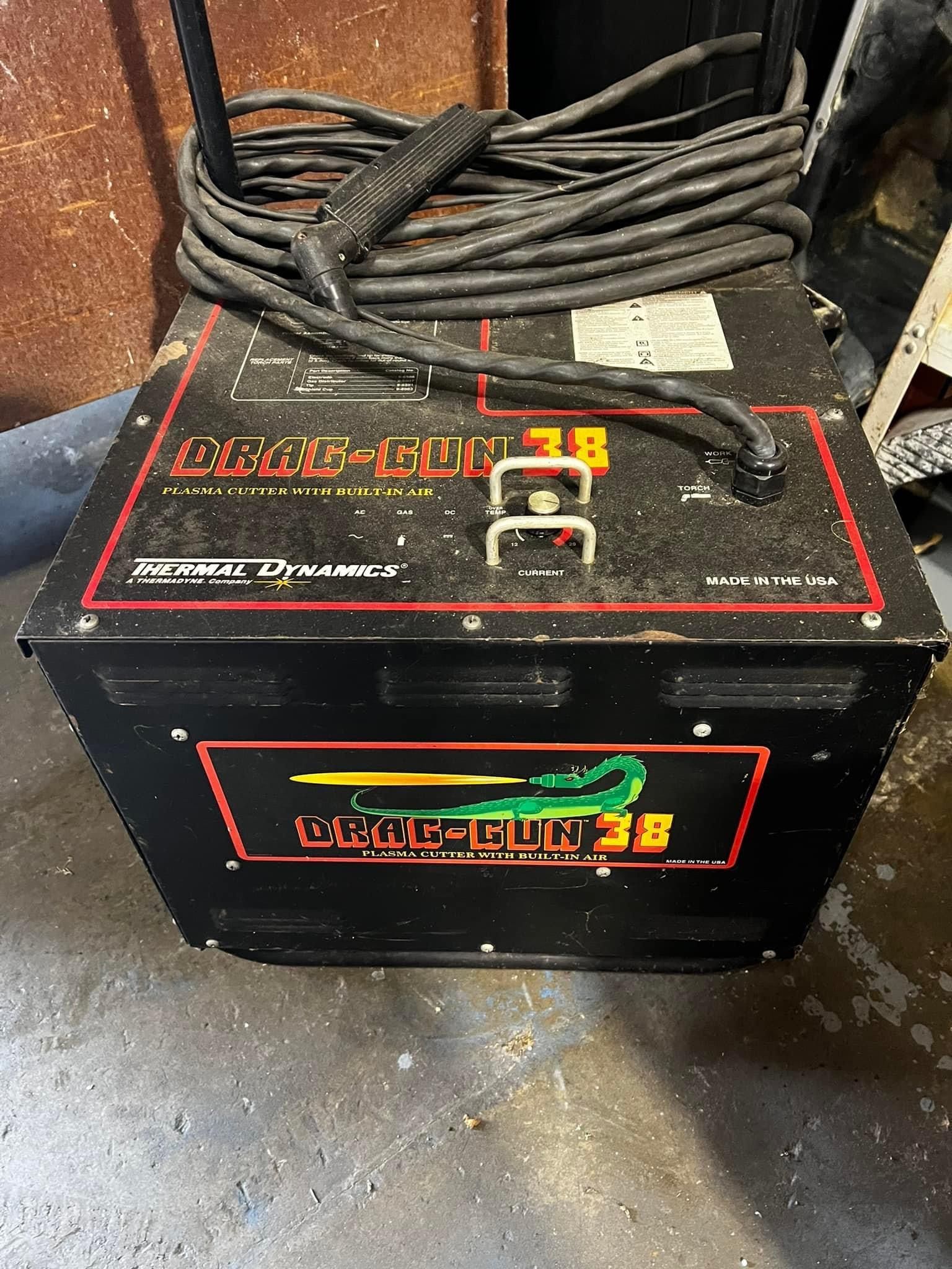 A black box with a hose attached to it is sitting on the floor.