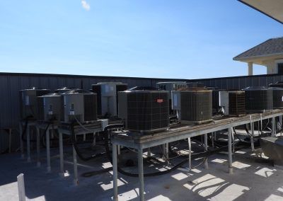 A bunch of air conditioners are sitting on top of a metal table.
