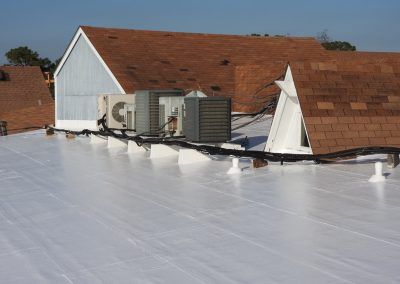 A white roof with a lot of air conditioners on it