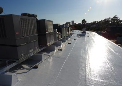A white roof with a lot of air conditioners on it.