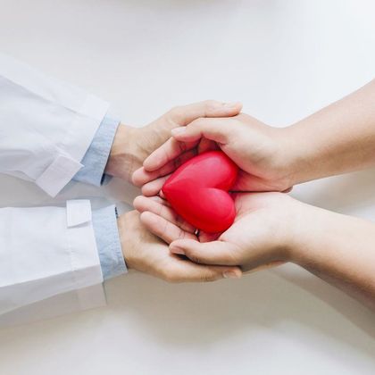 Hands holding a heart shaped paper weight