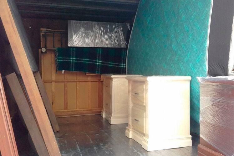 Una habitación llena de muchos muebles y un colchón.