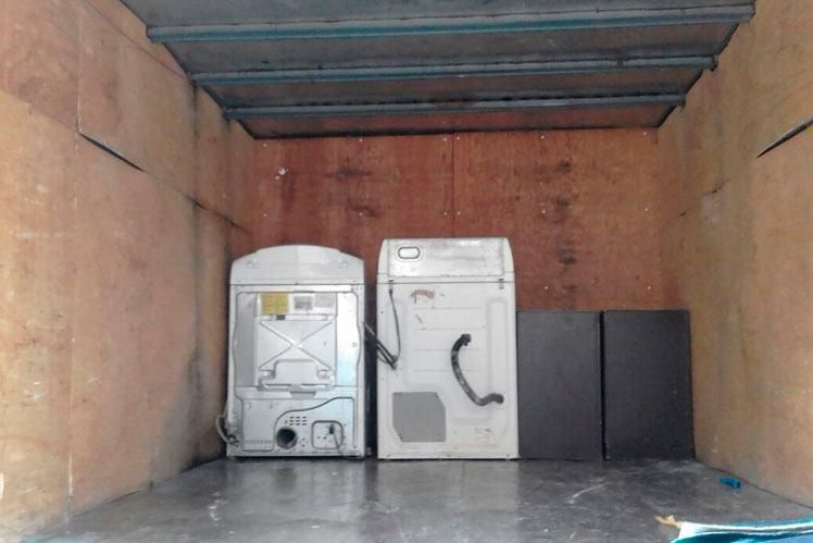 Una lavadora y una secadora están en la parte trasera de un camión.