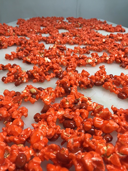 A bunch of red popcorn and nuts on a table